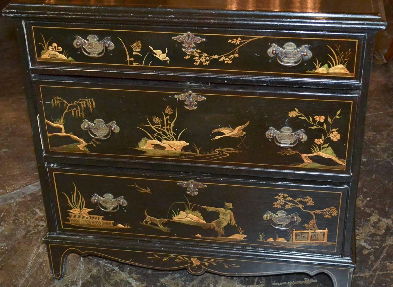 Alluring 19th century English chinoiserie black lacquered three-drawer chest. Having lovely landscape and scenic chinoiserie design with figures and fauna across drawer fronts and on all sides. Exhibiting a wonderful aged patina and clean lines that