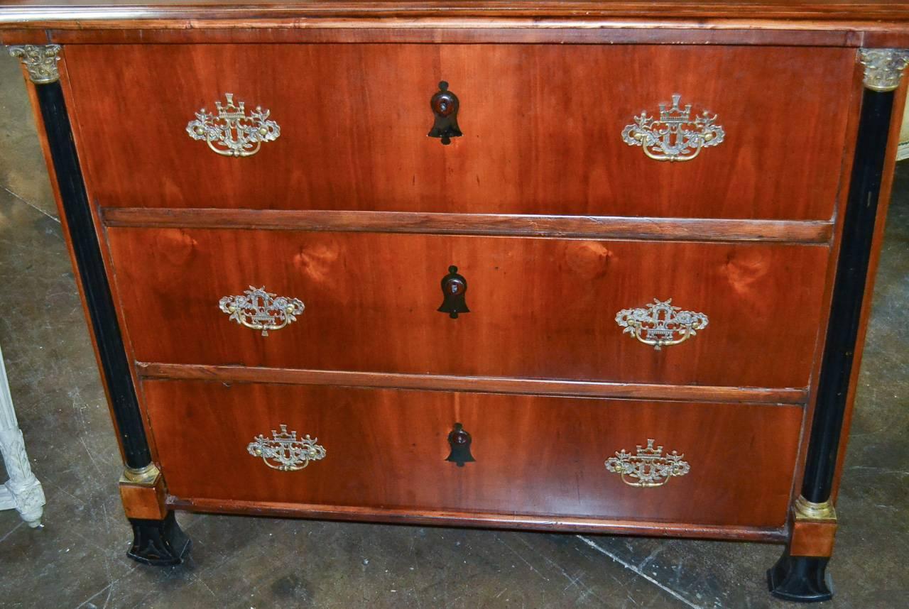 Sensational 19th century Continental mahogany and ebonized three-drawer commode. Having bronze hardware, ebonized columnar supports and keyholes and a beautiful warm and rich finish. A sophisticated piece with classic lines.