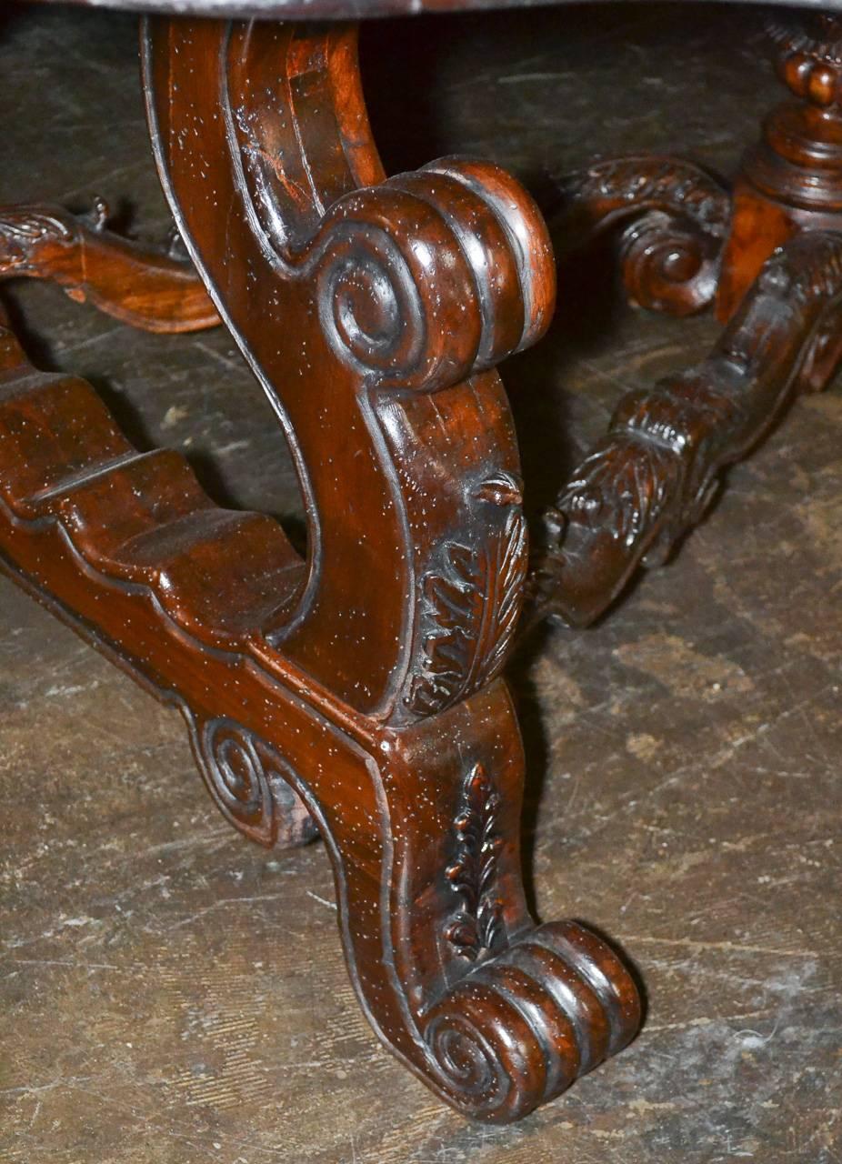 Sensational custom-made carved walnut center table. Having lovely carved legs and x-form stretcher, unusual top with inlaid border and exhibiting a deep rich finish. This piece available now.