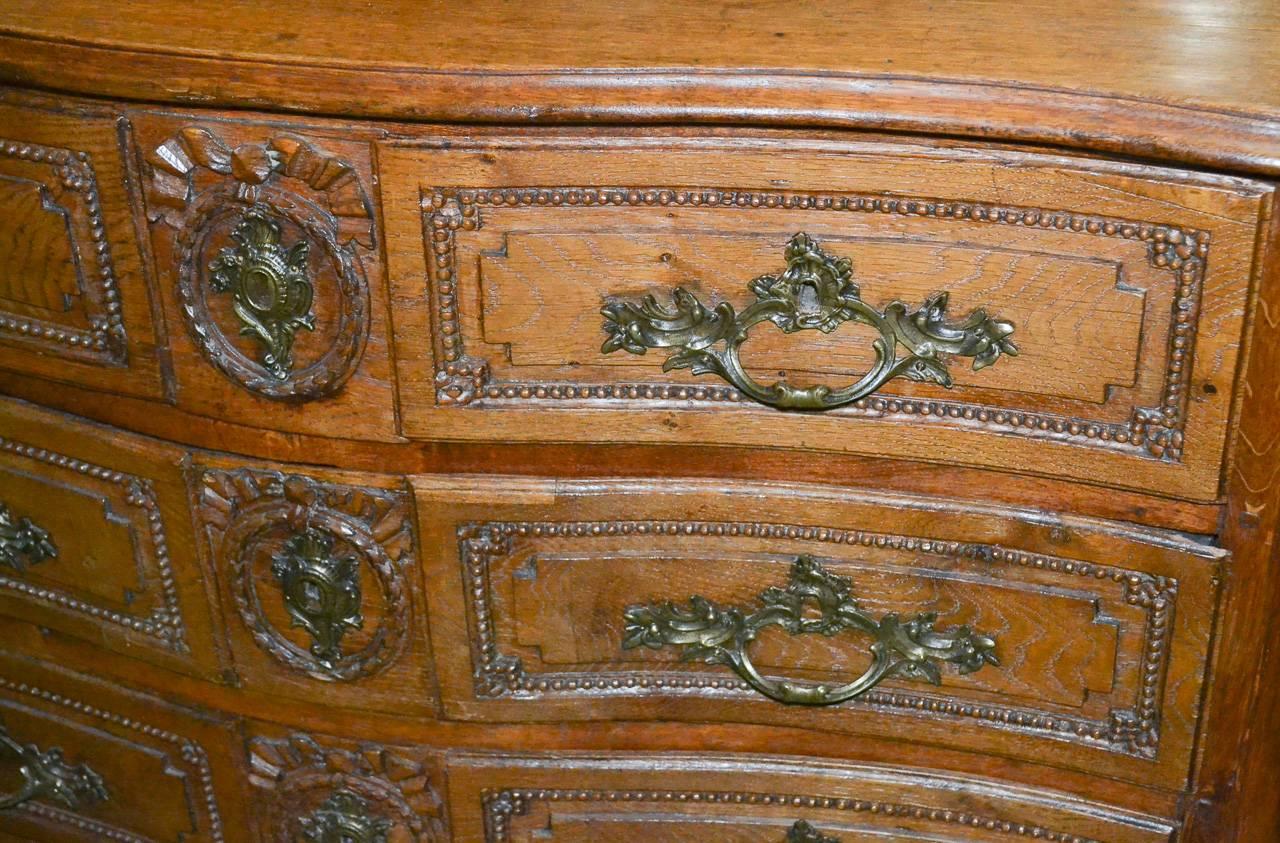 Magnificent 19th century French oak four-drawer commode. Having wonderfully carved shaped drawers, carved beading and ribbon motifs, gilt bronze hardware, and resting on cabriole legs. Exhibiting a beautiful patina and Classic lines.
 