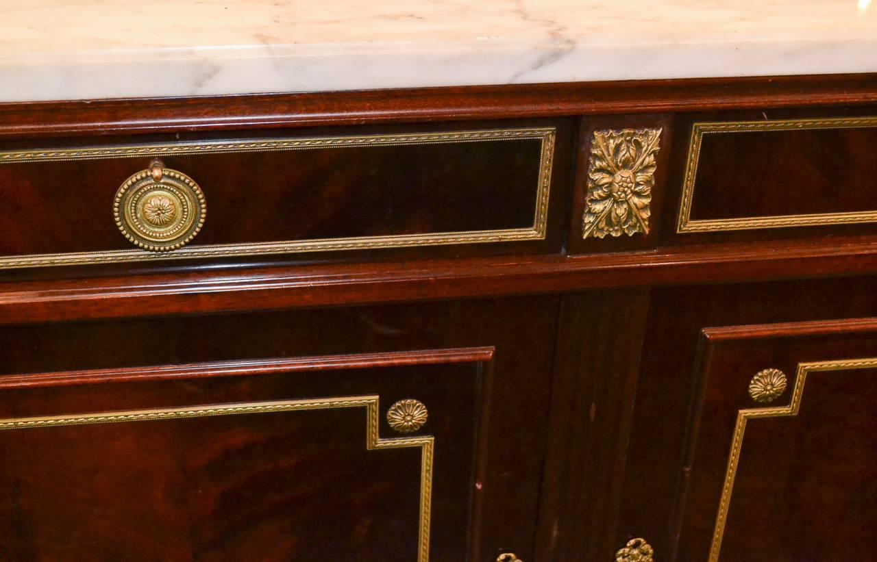 Exceptional Jansen mahogany five-drawer over five-door server. Having finely cast gilt bronze mounts and trim, wonderful Carrara marble-top and resting on tapered legs. A superb piece with Classic lines.