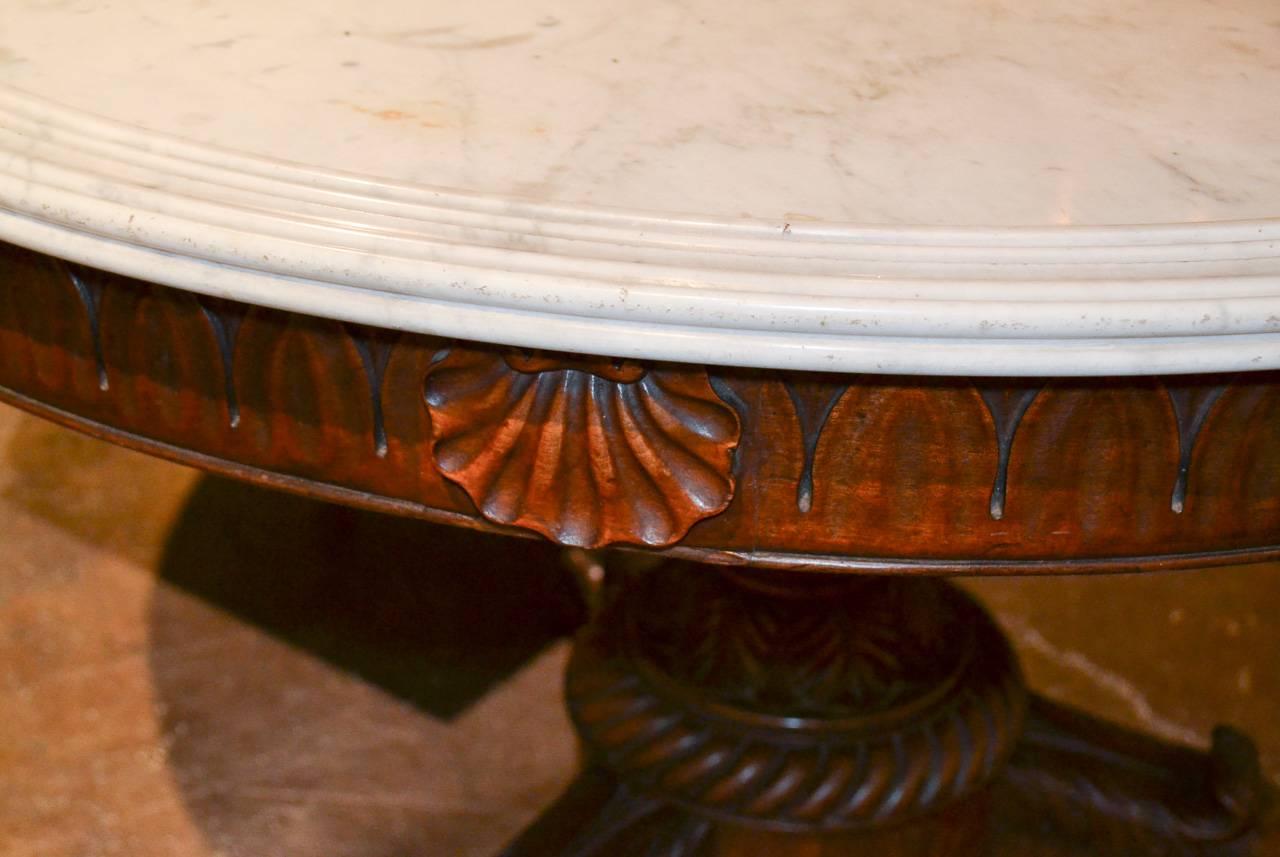 Excellent 19th century French Charles X mahogany centre table with Carrara marble top. Having wonderfully carved base with acanthus leaf motif, beautiful warm patina, and three legs terminating in claw feet. 