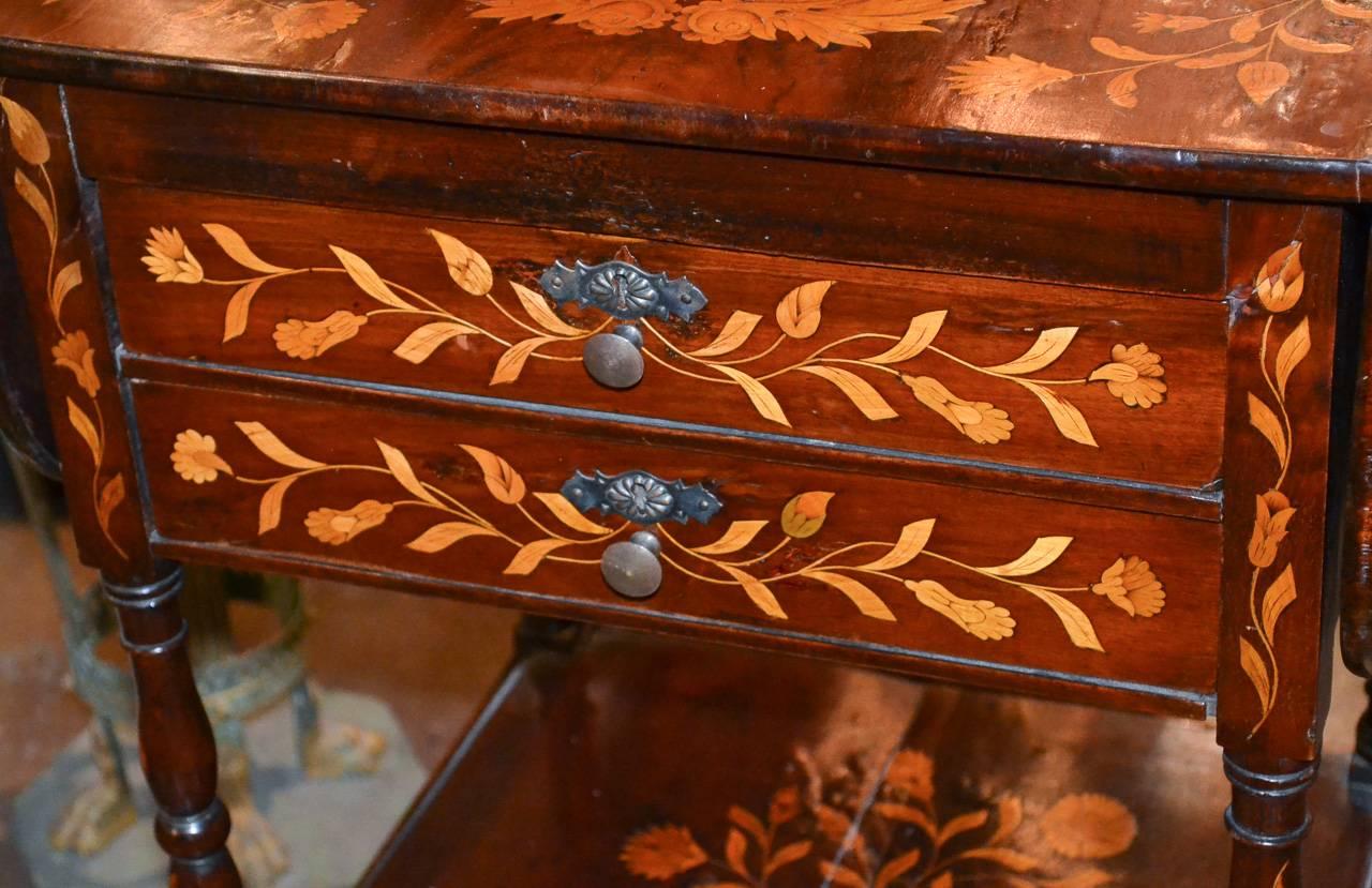 Splendid 19th century Dutch marquetry inlaid two-drawer Pembroke table having wonderful inlay work overall in floral and foliate motif. Possesses a rich warm patina and two versatile lower shelves, circa 1880.

Opened width 36.5