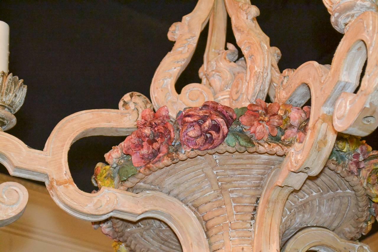 Delightful 19th century French hand-carved, bleached wood four-light chandelier. Having impressively carved frame with central basket and painted flowers, curved and scrolling arms terminating in flower inspired bobeche, and exhibiting a wonderful