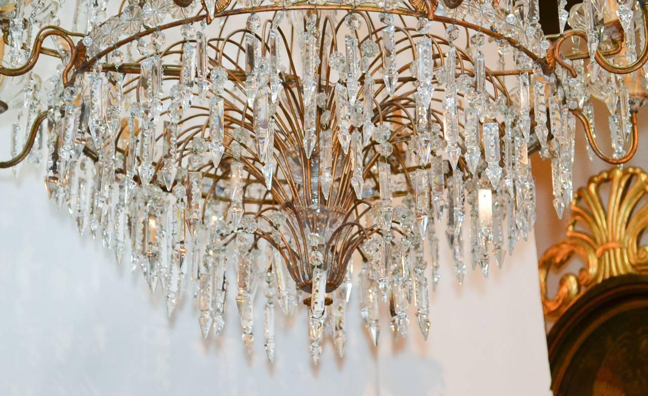 Sensational early 20th century French crystal waterfall eighteen-light chandelier. Wonderfully adorned with numerous crystal oil drop prisms, bobeches, and rosettes. 
 
