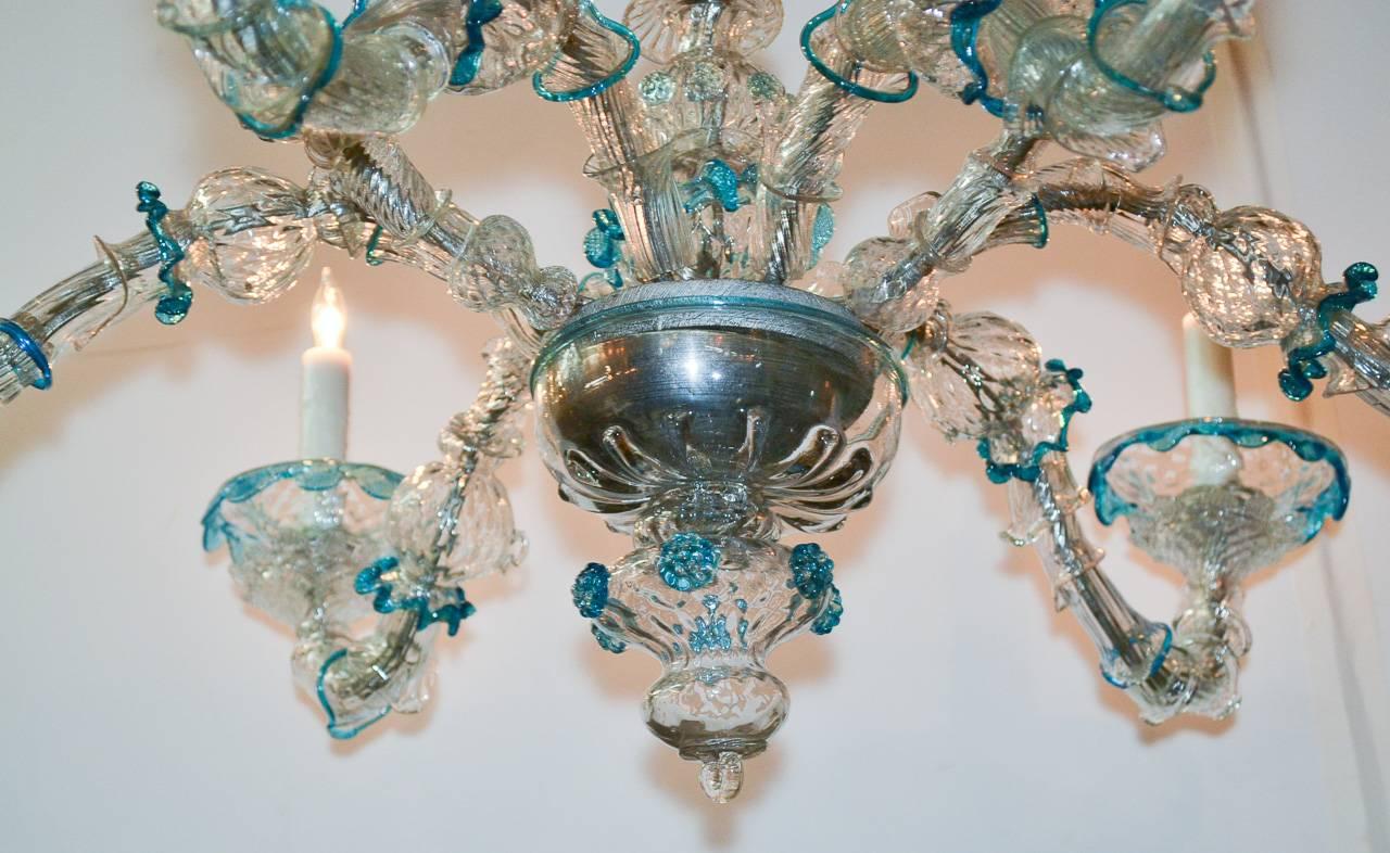 Merveilleux et rare lustre à six lumières en verre vénitien. Avec un beau cadre en verre soufflé avec de jolis accents bleus et verts, des bras et un corps gracieusement courbés et un embout intérieur en verre. 