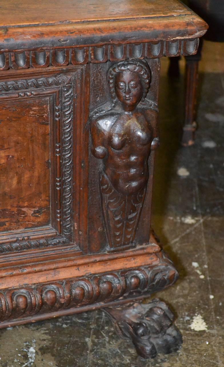 Attractive 18th century Italian carved walnut cassone. Having lovely hand-carved figural mounts, egg-and-dart trim, and resting on claw feet. Exhibiting a time worn patina that offers rich character and charm. 