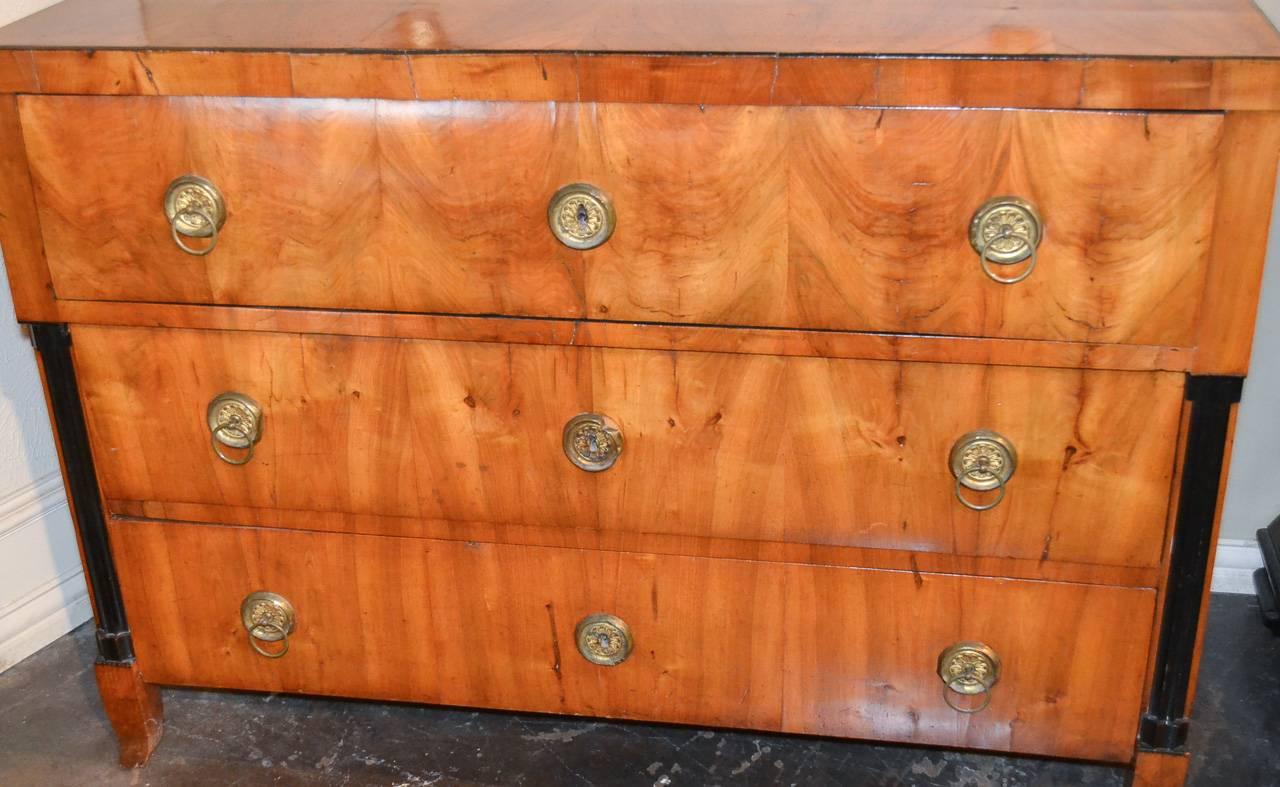 Wonderful 19th century continental walnut and ebonized three-drawer commode. Having gilt brass hardware, ebonized columnar supports, and a stunning rich patina.
