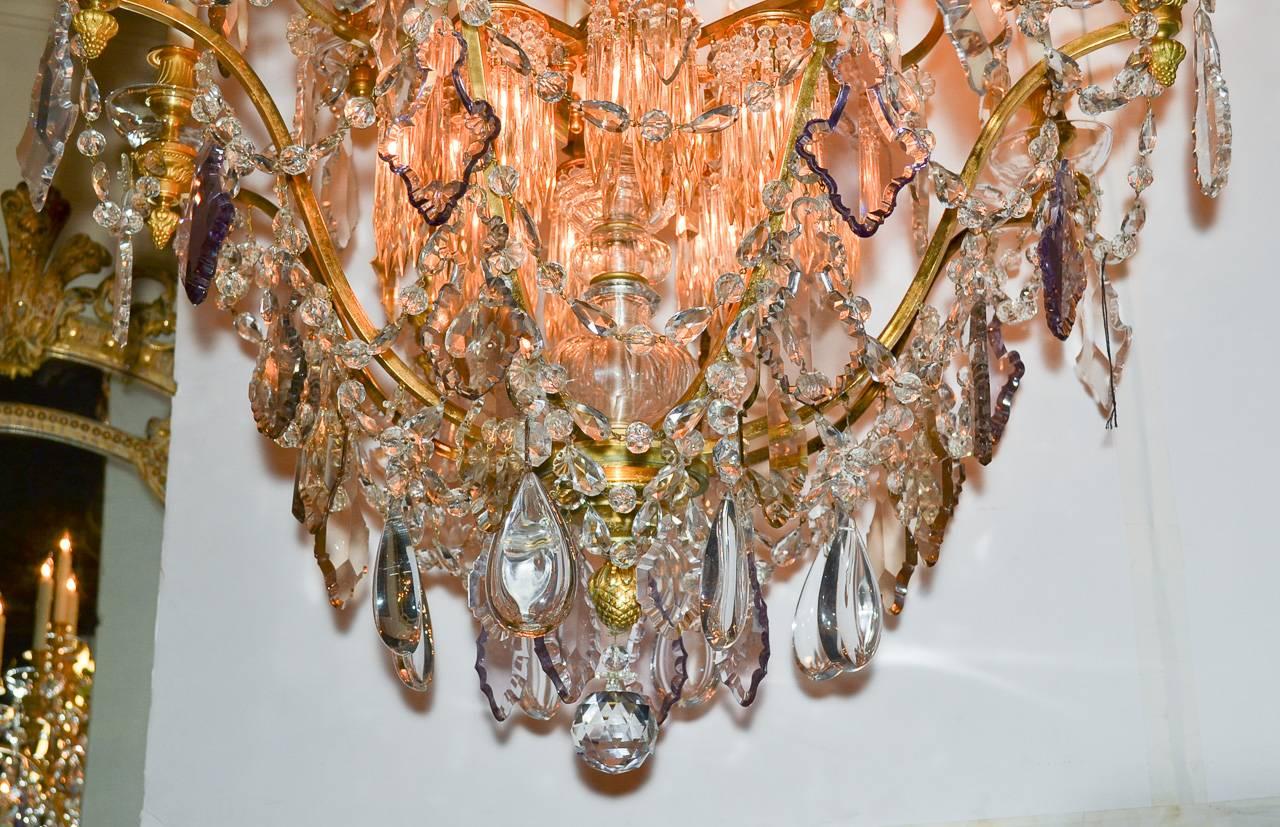 Truly magnificent 19th century French doré bronze and crystal twenty-light chandelier. Having elegant frame with lustrous gilt finish, impressive cut crystal column, beautiful lit crown and interior, and adorned with lovely thick beaded crystal