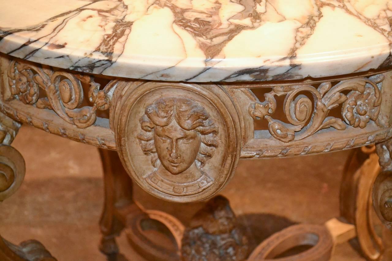 Sensational 19th century English hand-carved lime wood center table. Having beautiful Arabescato marble top, intricately carved ram's head legs terminating in cloven feet, and detailed carved figural masks on each side. Fabulous for numerous designs!