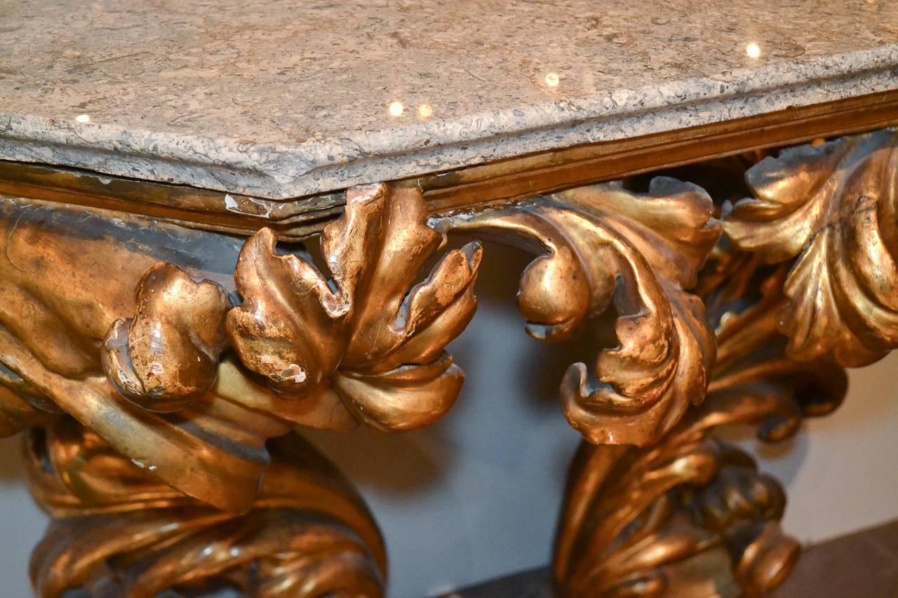 Magnifique console en bois doré sculpté florentin du début du 19e siècle. Avec un fantastique cadre sculpté en forme de feuille d'acanthe, une finition dorée lustrée et vieillie et un dessus en granit.