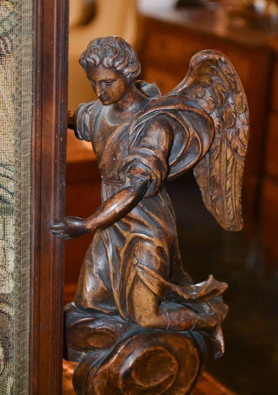 Marvelous 18th century Italian carved walnut plaque with original tapestry panel. Having wonderful hand-carved angelic figures resting on clouds flanking an original tapestry depicting Christ visited by winged putti. Exhibiting a time worn patina