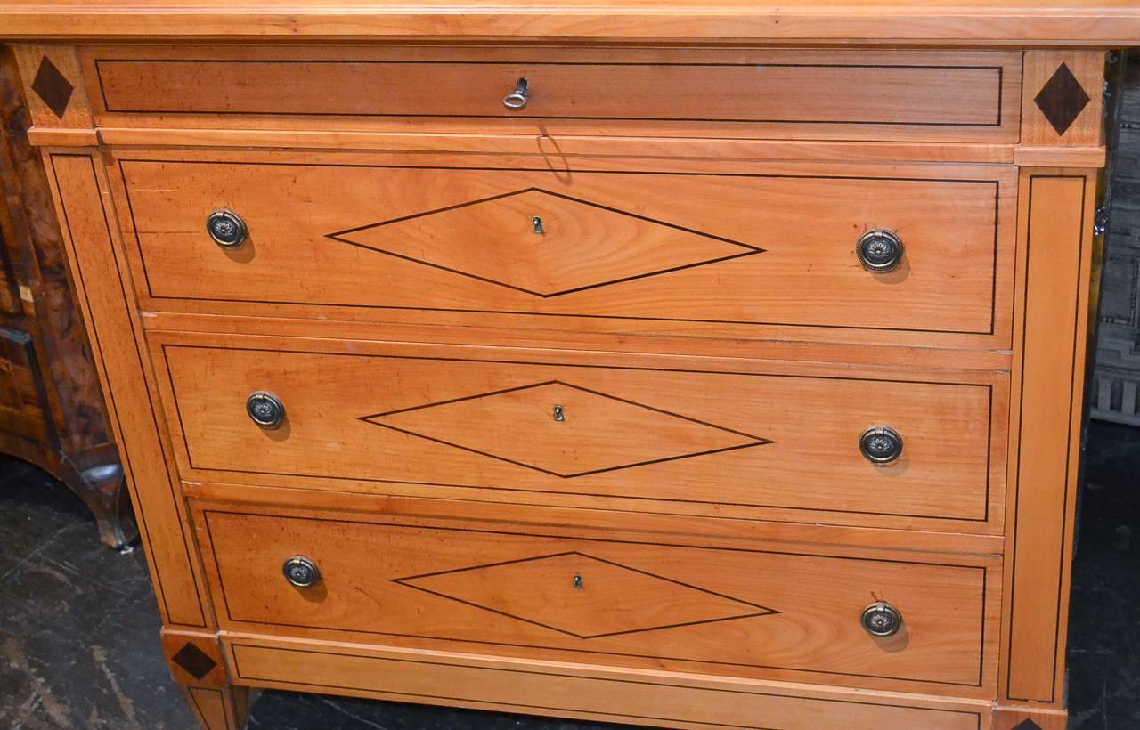 Excellent custom-made neoclassical four-drawer chest by Paris, France maker Schmidt. Having wonderful geometric inlays on all sides, great finish and patina, and resting on tapered legs. Featuring crisp lines.
 