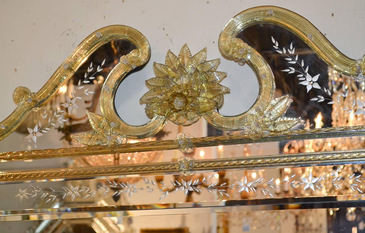Gorgeous Italian Venetian mirror trimmed in amber glass. Having lovely etched mirrored glass in foliate and floral motif and striking amber colored glass borders and pediment. Wonderful for numerous designs!

Over 100 French and Italian antique