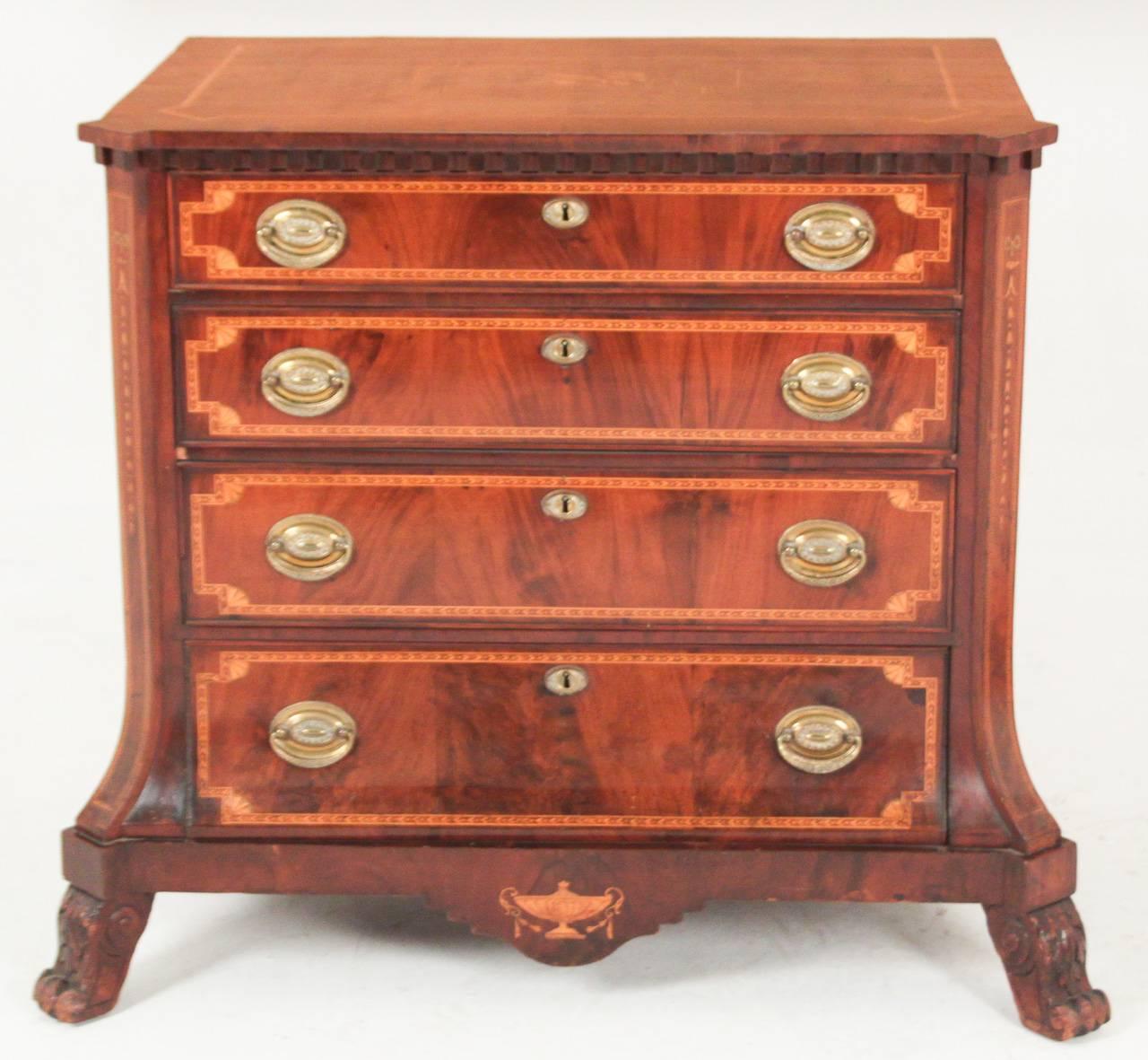 Wonderful early 19th century Dutch neoclassical inlaid four-drawer commode. Having intricately detailed inlays on all sides with musical motif inlay on top, brass hardware, and resting on scrolled claw feet. 
