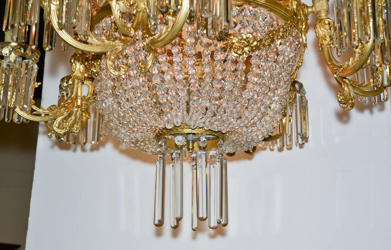 Exceptional 19th century French gilt bronze and beaded crystal 12-light chandelier. Having beautiful gilt bronze frame with swag and acanthus leaf motif, lovely reticulated basket frame, and adorned with large beaded strands and drop prisms. 