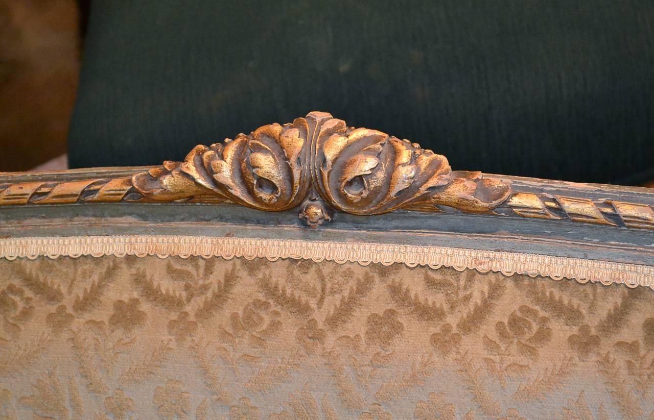 Delightful 19th century French Louis XVI parcel-gilt settee. Having graceful curved form, wonderful carved frame with guilloche and acanthus leaf accents and resting on fluted tapered legs. 