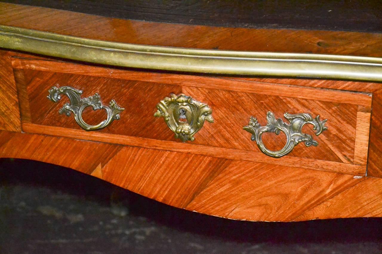 Excellent 19th century French walnut and bronze two-drawer bureau plat. Having gilt bronze trim and mounts, tooled leather top, and resting on cabriole legs. Fabulous for numerous designs!