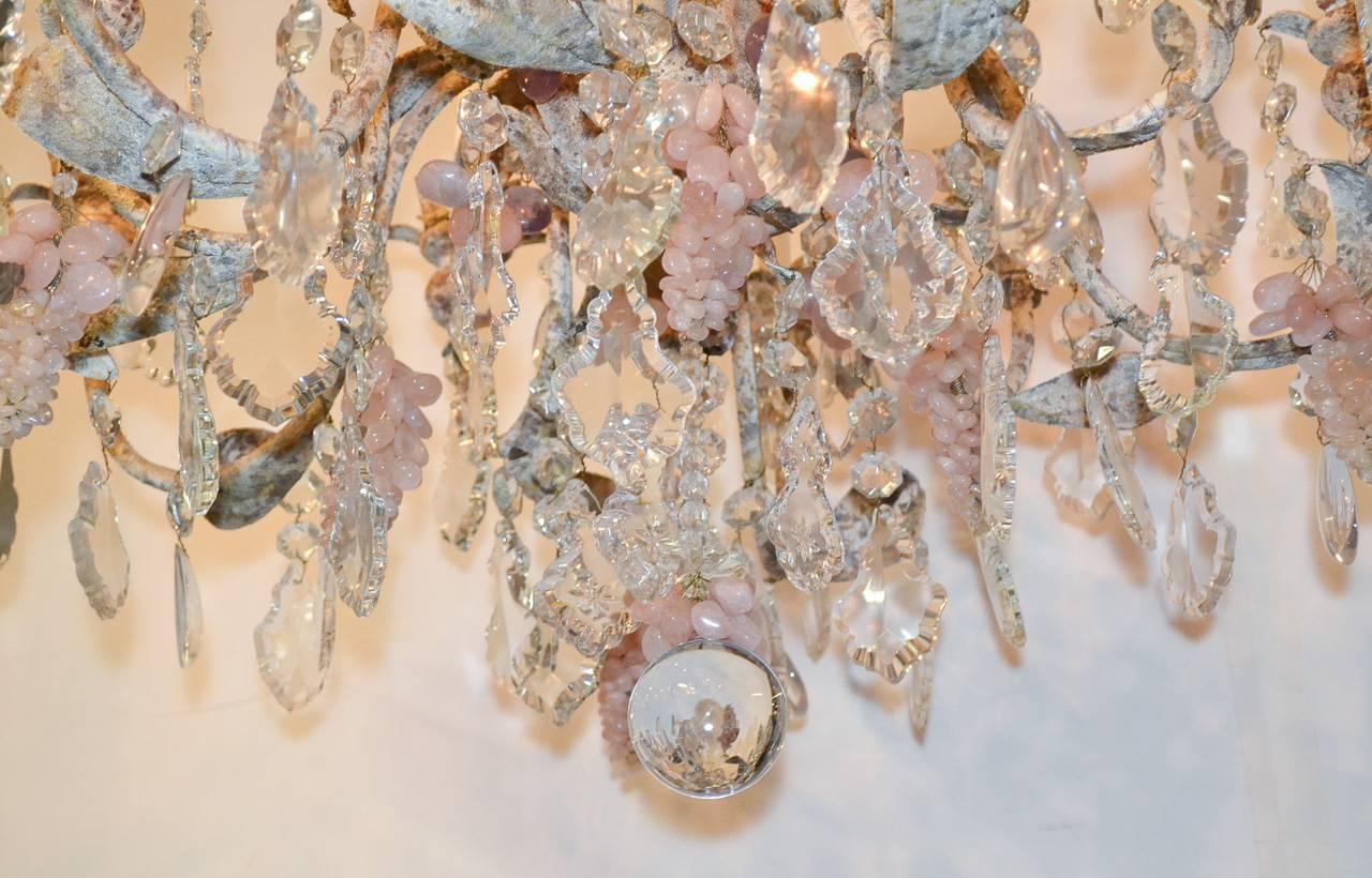 Wonderful French iron, crystal, and rose quartz ten-light chandelier. Having patinated iron in foliate form, large pendeloque crystal prisms, and adorned with rose quartz grape clusters and tear-drop prisms. Ready for your designer touch!