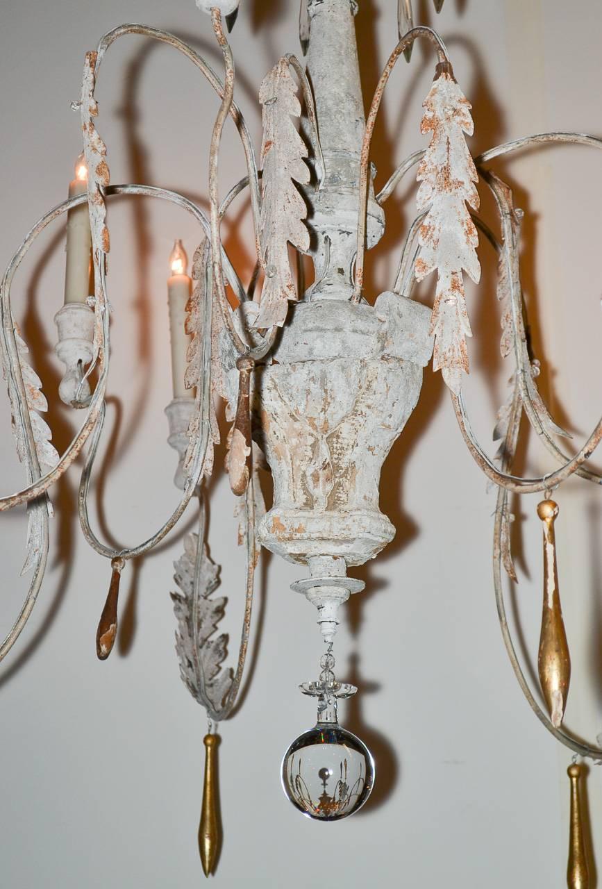 Lovely Italian painted carved wood and metal nine-light chandelier. Having gracefully curved arms with acanthus leaf and parcel-gilt adornments. Exhibiting a wonderful painted patina perfect for numerous designs!