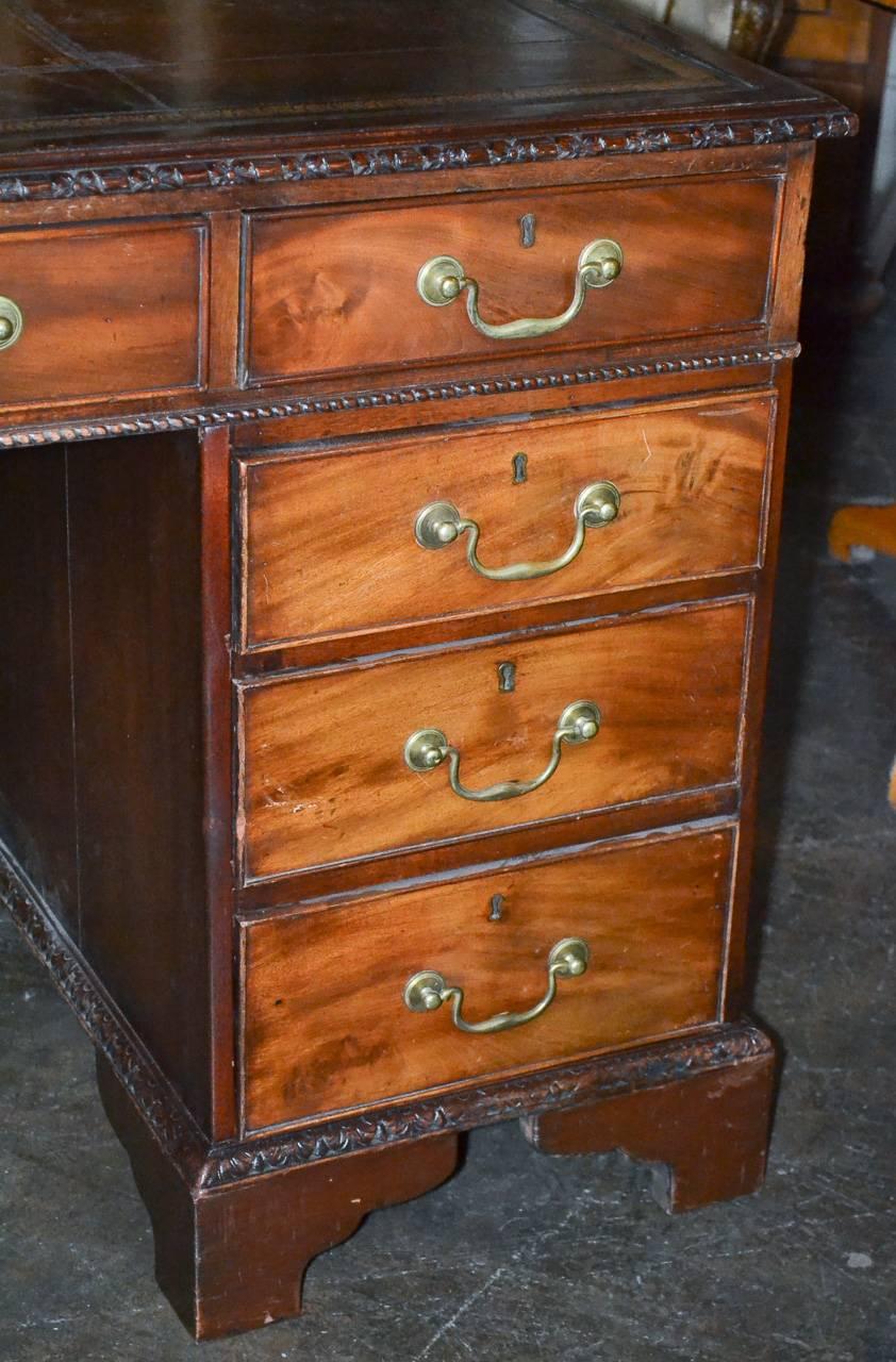Attractive 18th century English mahogany partners desk (probably Georgian). Having nine drawers on one side and three-drawers over two-doors on reverse. Featuring a wonderful original tooled leather top, brass hardware, and a lovely aged patina. A