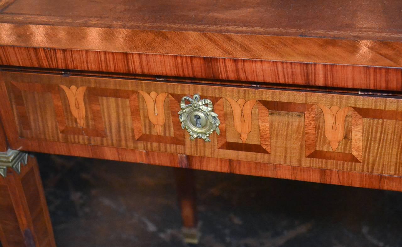 Fantastic French transitional kingwood two-drawer desk with parquetry inlays. Having lovely geometric inlays on all sides, beautiful gilt bronze mounts, and tooled leather top. Exhibiting a wonderful patina and clean lines that work in countless