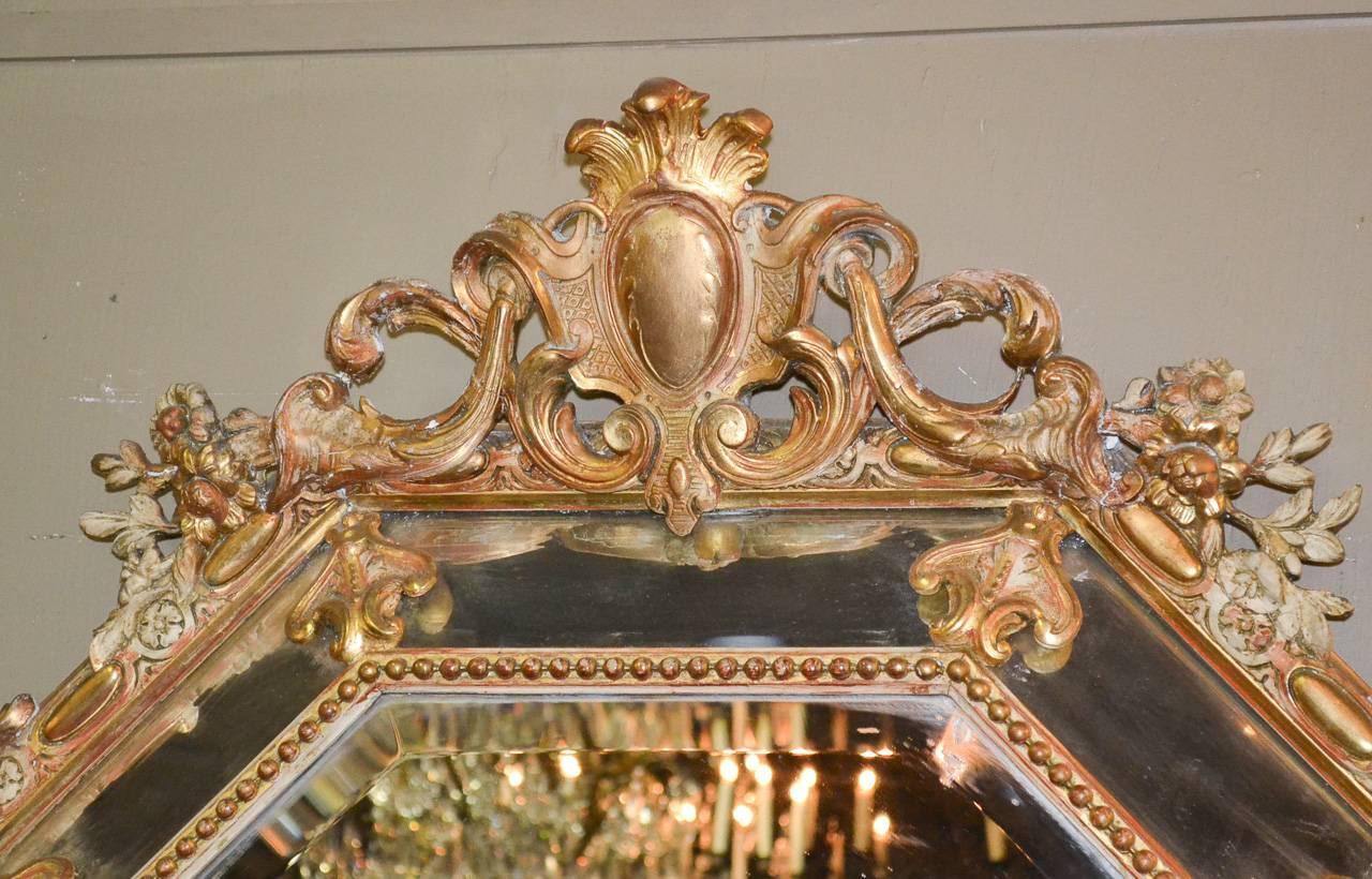 Beautiful 19th century, French octagonal giltwood cushion mirror. Having wonderfully carved frame in acanthus leaf and floral motifs, beaded frame around beveled mirrored glass, and a fabulous gilt patina. Perfect for today's stylish decors!