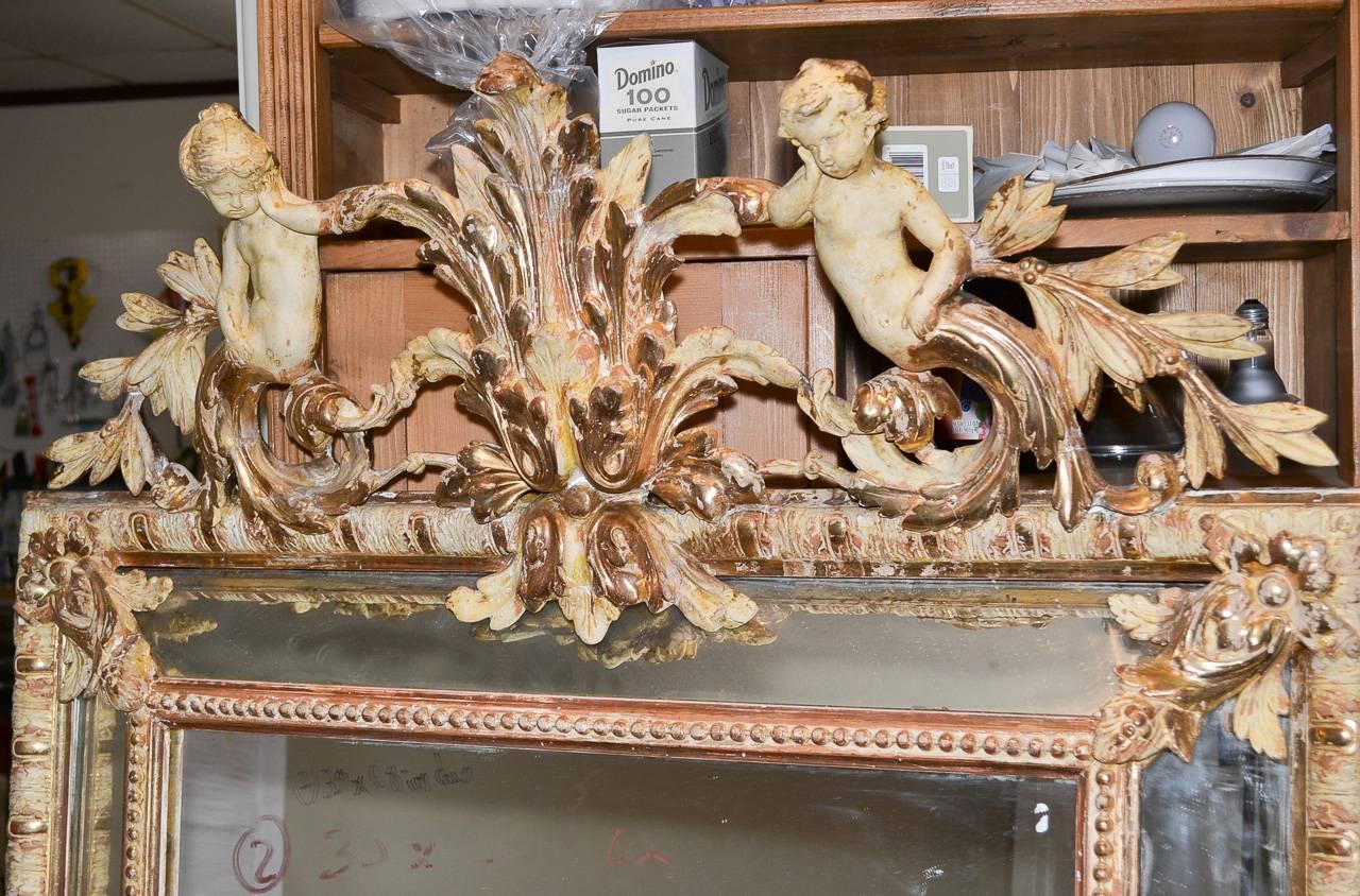 Superb 19th century French Louis XV cushion mirror. Having wonderfully carved cartouche in acanthus leaf and putti motif, a beautiful gilt and gesso finish with water-gilt highlights, and of excellent size. An excellent piece with classic lines to