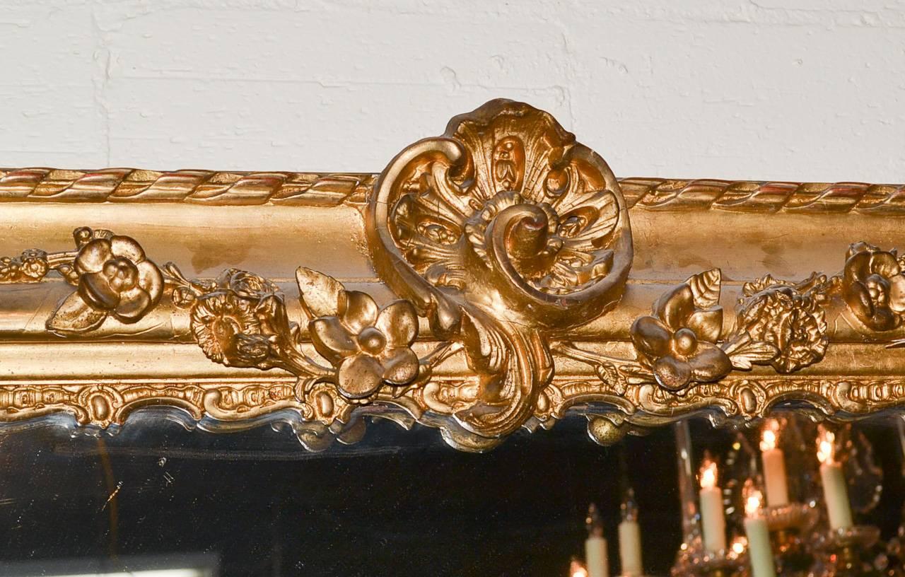 Impressive 19th century palace size French Baroque giltwood mirror. Having a lovely carved frame in acanthus leaf and floral motif, and exhibiting a lustrous gilt patina. Fabulous for numerous designs!