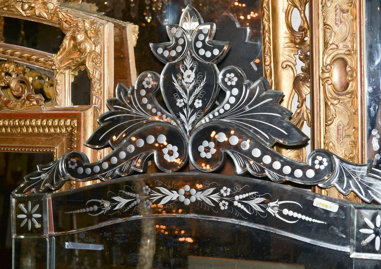 Wonderful large Venetian etched glass mirror. Having beautiful shaped cartouche, delicate foliate motif etching, and classic lines to suit a variety of decorative styles!