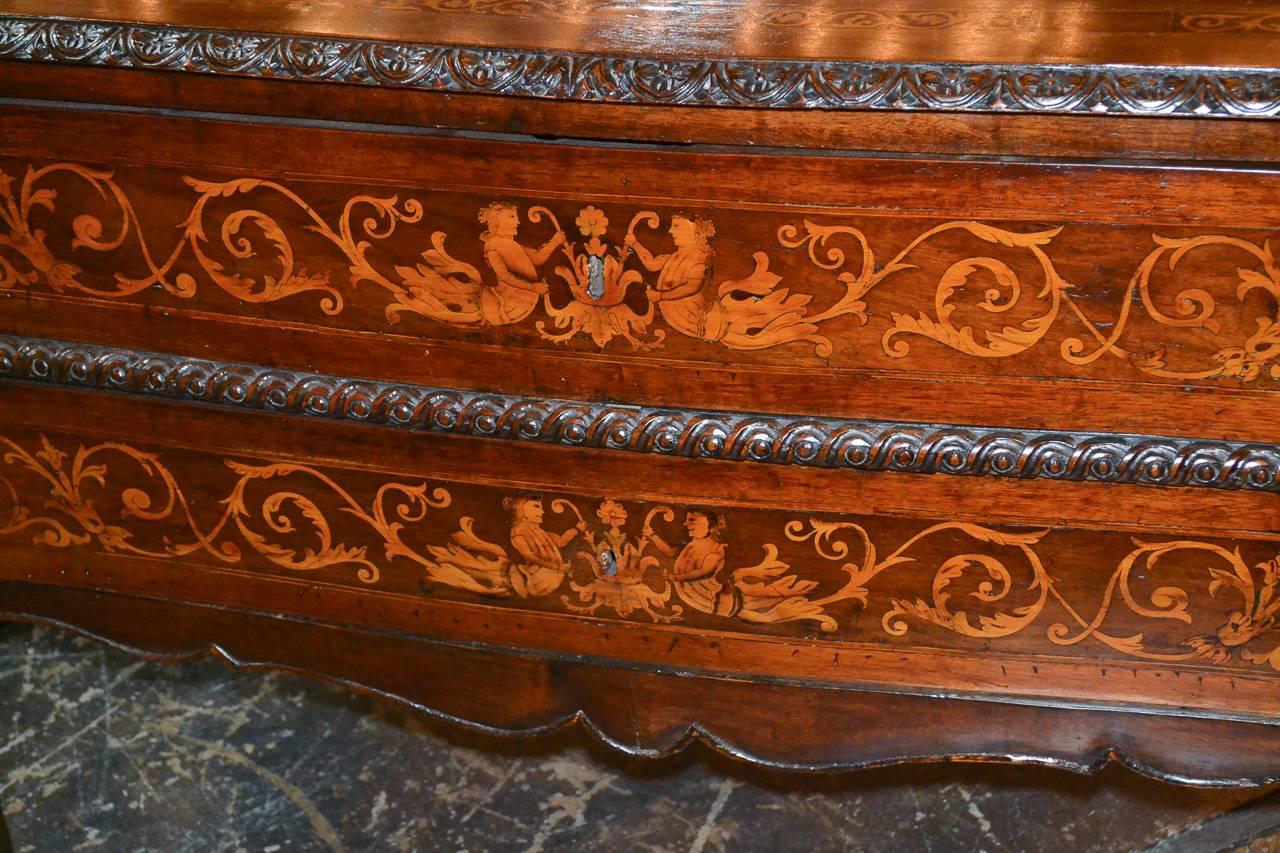 Marvelous 18th century Northern Italian two-drawer walnut commode. Having lovely marquetry inlays in figural and acanthus leaf motif, detailed carved trim, and resting on cabriole legs. Fabulous for numerous designs!