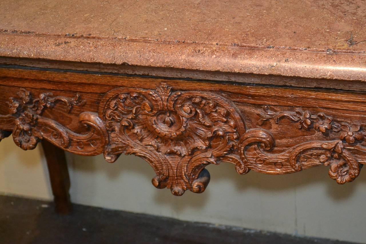 Beautiful 18th century French Provincial carved oak console.  Having wonderfully carved frieze and legs in acanthus leaf and floral motif, thick marble top, and resting on cabriole legs.  Exhibiting a gorgeous patina with classic lines to suit a