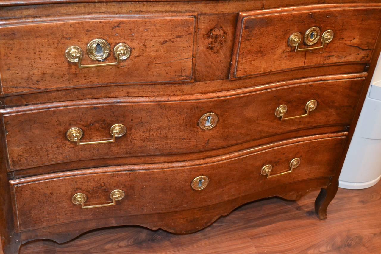 Handsome 18th century French Provincial 4-drawer walnut commode.  Having lovely gilt bronze hardware, beautiful aged patina, and resting on cabriole legs. This piece is splendid and worthy of any design!