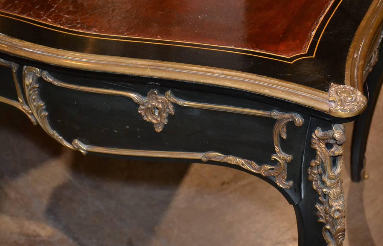 Marvelous French Louis XV black lacquered three-drawer bureau plat. Having gilt bronze mounts and trim, tooled red leather top, and resting on cabriole legs. A great piece with Classic lines to suit a variety of decorative styles!