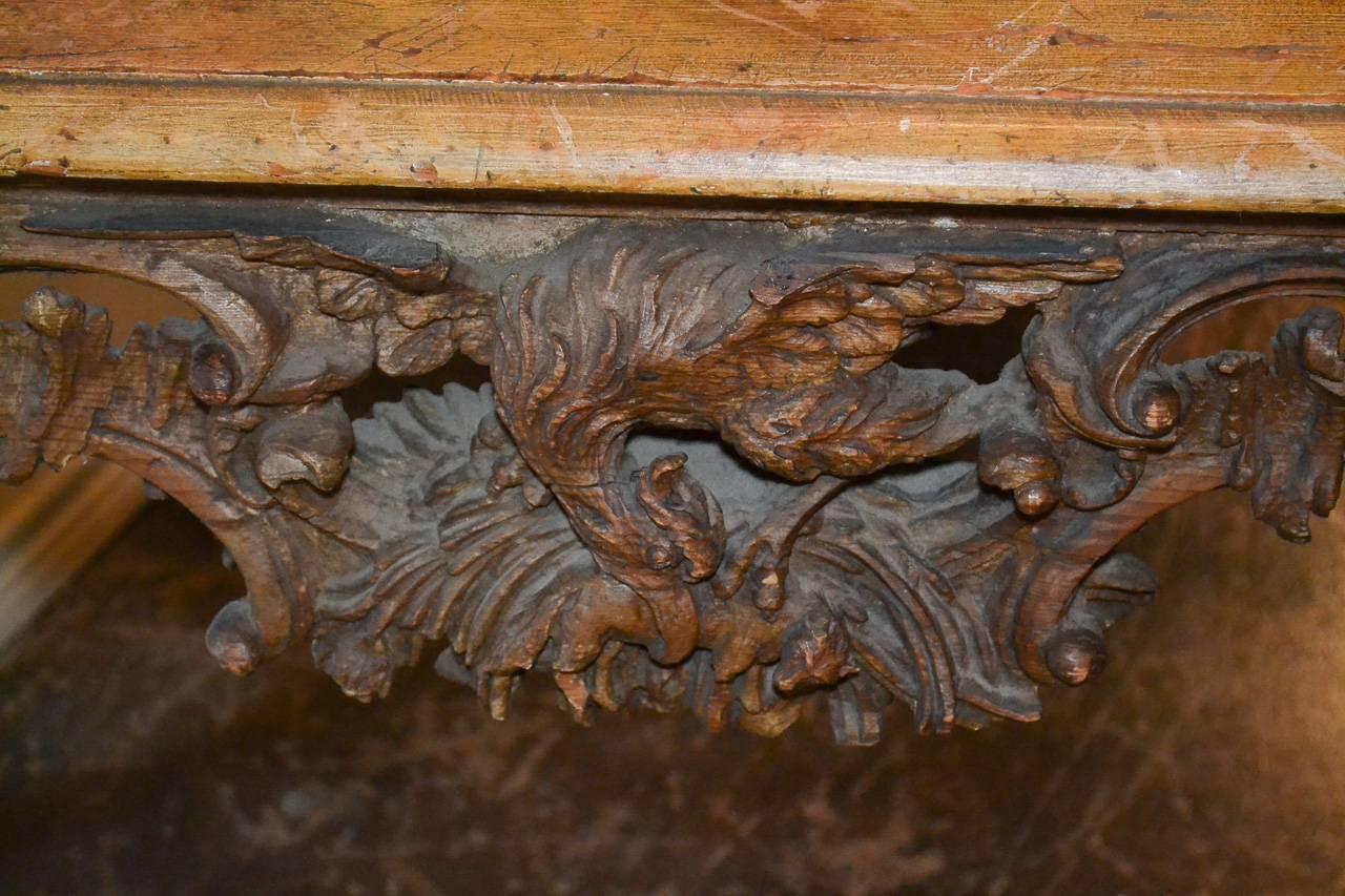 Wonderful 18th century Italian carved console. Having lovely hand-carved reticulated frieze with bird of prey, carved legs in acanthus leaf motif, and lacquered top. Exhibiting a beautiful time worn patina that offers rich character and charm!