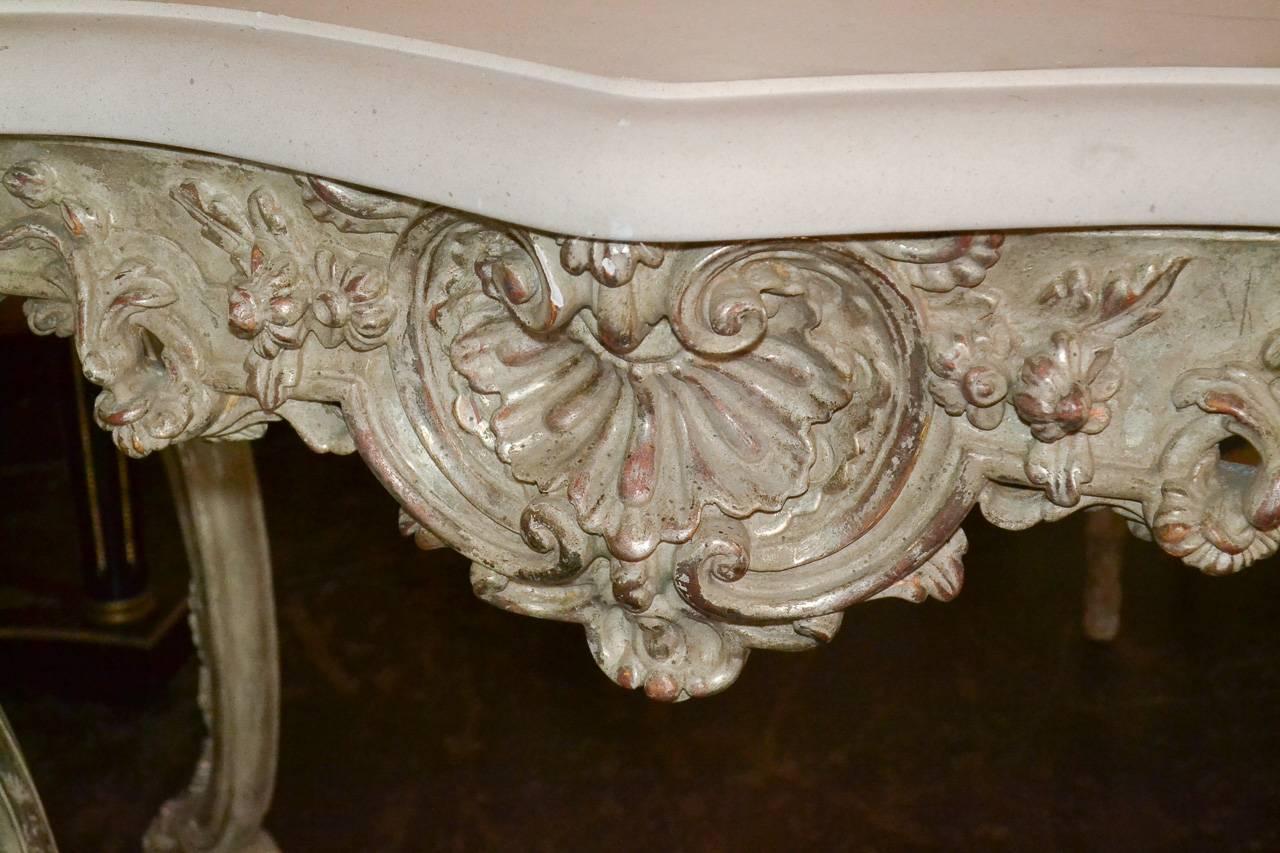 Attractive Italian carved console with silver gilt finish. Having wonderful carved frieze and legs in acanthus leaf motif, thick limestone shaped top, and lovely patina. Fabulous for numerous designs!