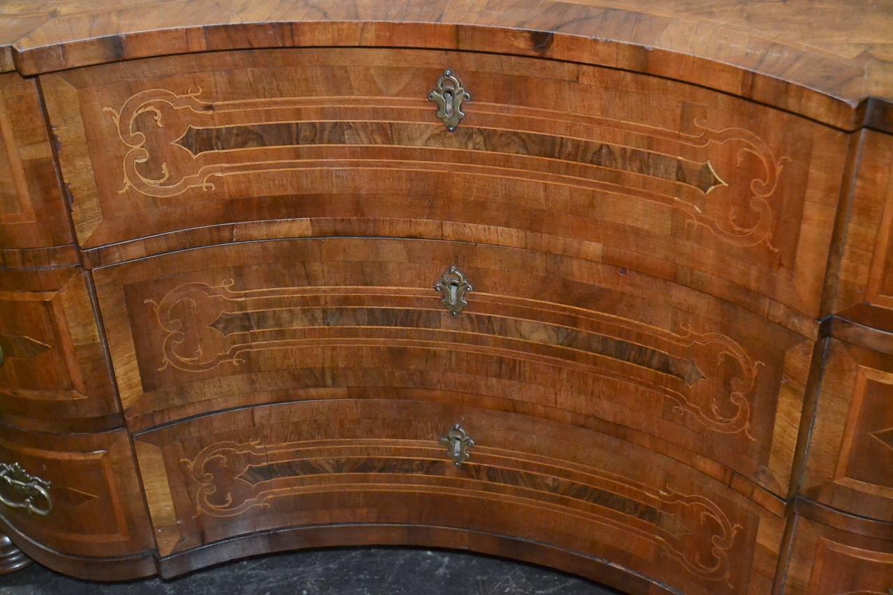 Superb 19th century Italian walnut inlaid three-drawer commode. Having wonderful shaped front, stylish geometric inlays, bronze hardware, and resting on turned feet. Exhibiting a rich warm patina perfect for many decorative styles!