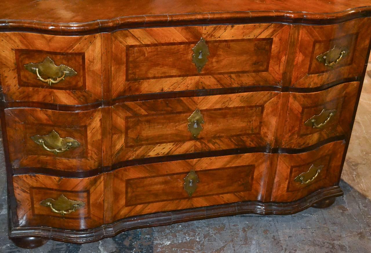 Exceptional 18th century South German walnut three-drawer commode. Having shaped front, simple geometric inlays, wonderful aged patina and resting on bunn feet. Fantastic for numerous designs.
