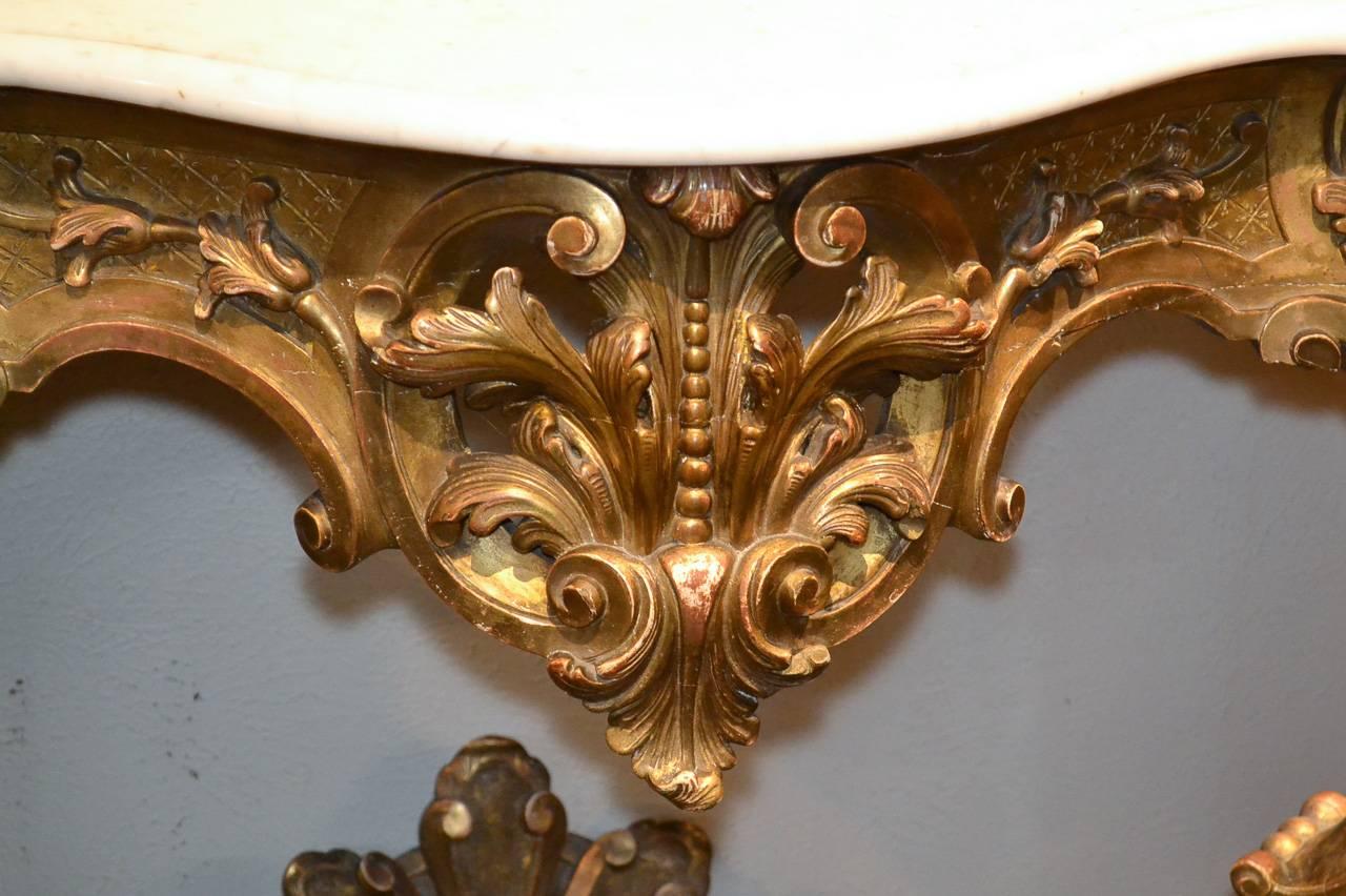 Superb 19th century French Louis XV giltwood console. Having beautifully carved reticulated frieze and stretcher in acanthus leaf motif, Carrara marble top, and lustrous aged gilt patina. Fabulous for numerous designs!