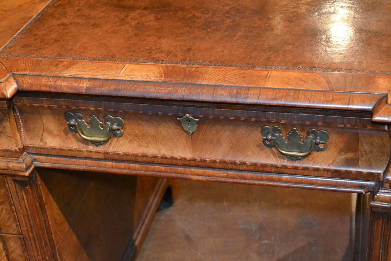 Attractive 19th century English burl walnut nine-drawer desk. Having stylish geometric inlays across shaped drawer fronts and top, lovely tooled leather writing area, and exhibiting and beautiful warm rich patina. Fabulous for numerous designs!