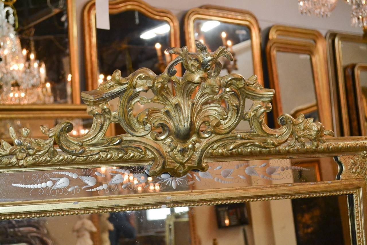 Radiant 19th century French carved giltwood mirror with etched glass. Having lovely carved cartouche in acanthus leaf motif, delicate etched designs along border, beaded frame, and a wonderful aged gilt patina. Perfect for today's stylish decors!