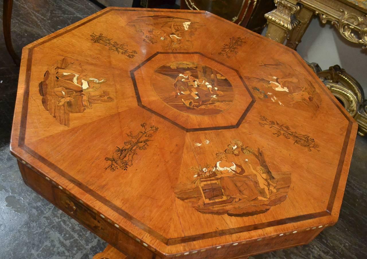 Spectacular 19th century Austrian inlaid mahogany octagonal center table signed L.M.F.  Having incredible inlaid figural scenes overall incorporating bone and mother-of-pearl, 2 drawers along the detailed apron, and resting on any equally detailed