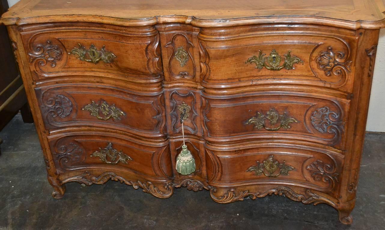 Exceptional 18th century French walnut 3-drawer commode from Lyon.  Having beautifully carved and shaped drawer fronts, bronze hardware in acanthus leaf motif, and a stunning aged-to-perfection patina.  An impressive piece with classic lines to suit