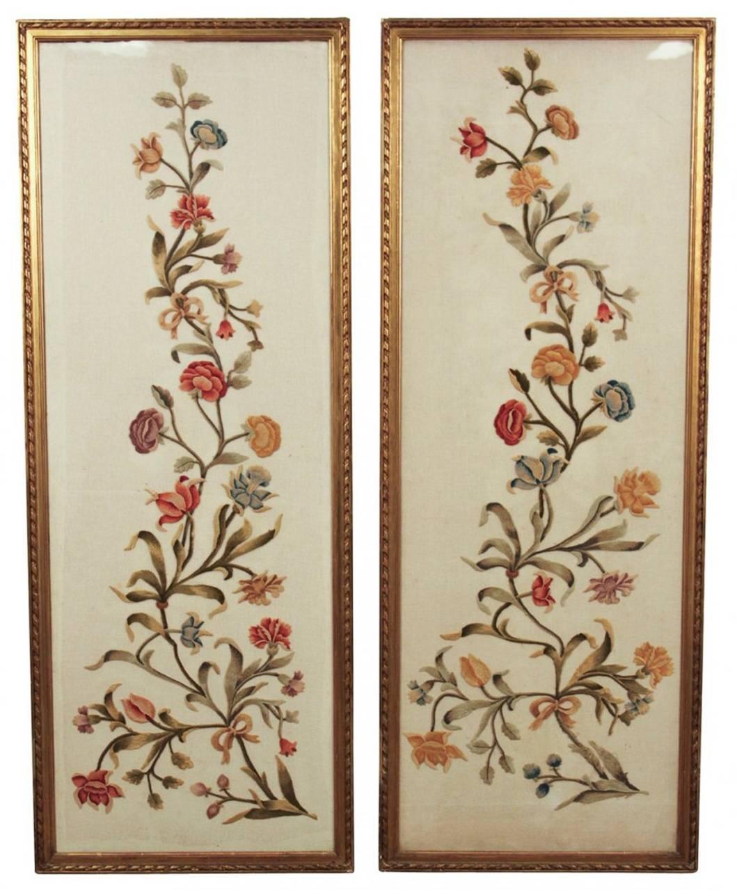 A pairnoffine silk embroidered vertical panels framed and under glass. Having beautiful hand-sewn floral designs in colorful hues, lovely giltwood frames, and of desirable size and proportions. Ready for your designer touch!