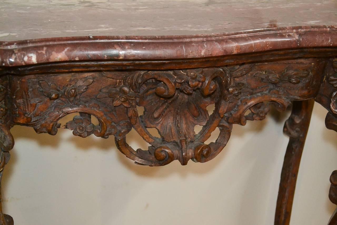 Lovely 18th century French hand-carved walnut console. Having wonderfully carved reticulated frieze in acanthus leaf motif, beautiful thick Rouge du Maine marble top, and resting on cabriole legs. A charming piece perfect for many designs!
