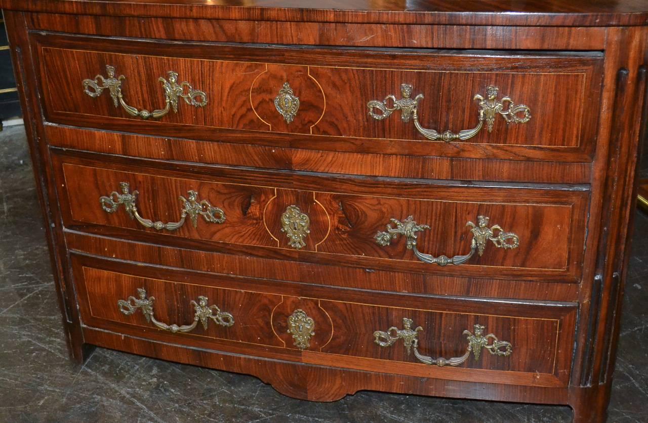 Impressive 18th century French Regency rosewood three-drawer commode. Having inlays on all sides, detailed bronze hardware, and beautiful rich aged patina. A handsome piece for numerous designs!