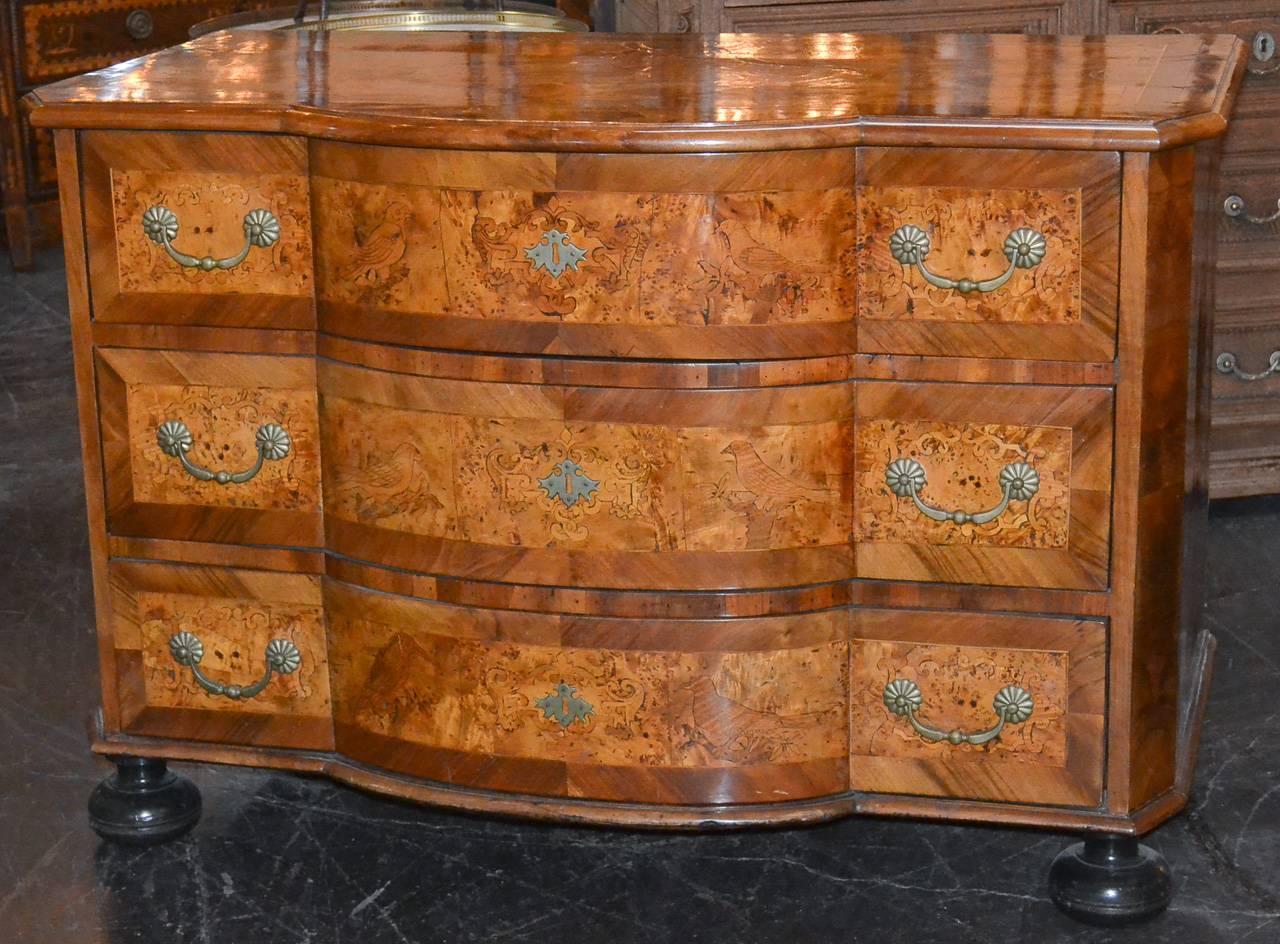 Magnificent 18th century south German burl walnut three-drawer commode. Having beautiful marquetry inlays overall with bird motif inlays across the bowed drawer fronts. Showcasing a gorgeous warm aged patina and resting on bunn feet. A fantastic