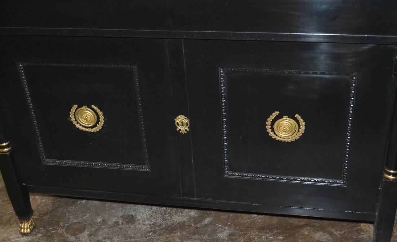 Nice quality French Empire black lacquered 2-door buffet. Having detailed gilt bronze hardware and mounts, flanked with columnar supports, and legs terminating in claw feet.  Exhibiting a stunning black finish excellent for various decorative