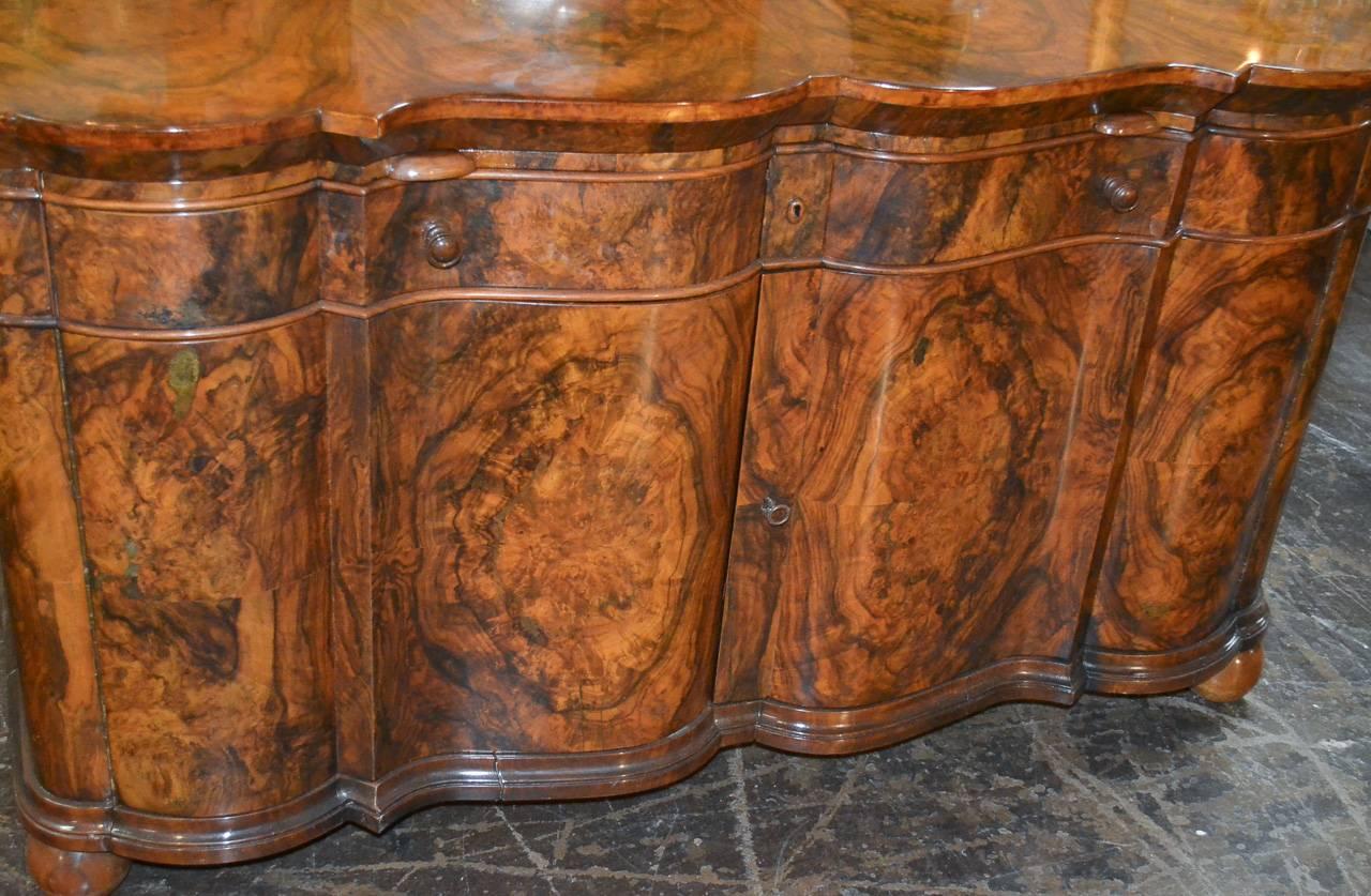 Great quality Italian burl walnut two-drawer over two-door buffet. Having impressive shaped front, stunning finish and patina, and resting on ball feet. Fabulous for numerous designs!