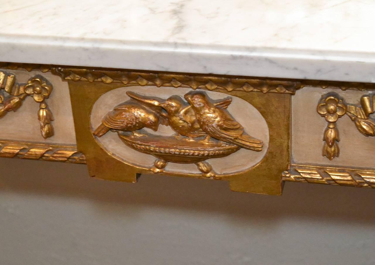 Fabulous parcel-gilt carved Jansen console with Carrara marble top. Having lovely carved details in bird, lion, and swag motifs. Featuring a beautiful painted and parcel gilt finish, wonderful aged patina, and resting on tapered fluted legs. Beyond